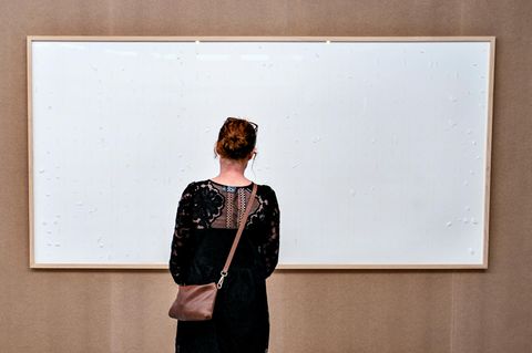 Eine Frau schaut auf ein leeres, weißes Bild im Kunsten Museum in Aalborg