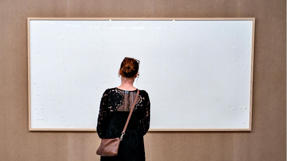 Eine Frau schaut auf ein leeres, weißes Bild im Kunsten Museum in Aalborg