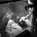 An einer dreidimensionalen Schädelrekonstruktion werden per Hand kleinste Ungenauigkeiten behoben