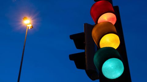 Leuchtende Ampel vor Dämmerungshintergrund