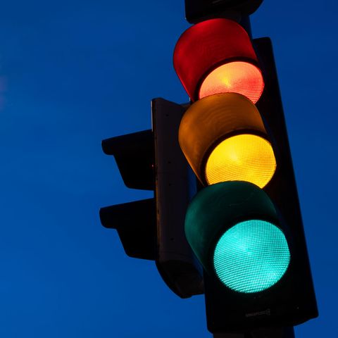 Leuchtende Ampel vor Dämmerungshintergrund