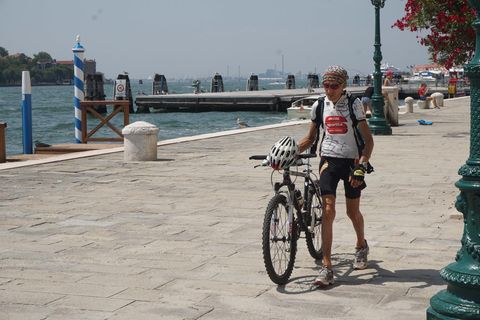 Mann schiebt sein Fahrrad durch die Altstadt von Venedig