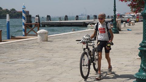Mann schiebt sein Fahrrad durch die Altstadt von Venedig