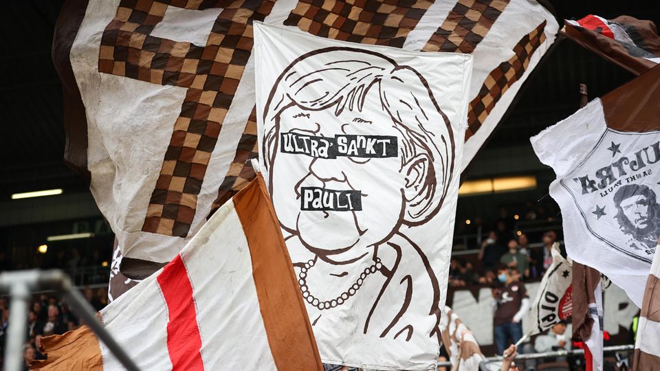 Ein Banner mit einer Zeichnung von Angela Merkel im Fanblock des FC St. Pauli Ein Banner mit einer Zeichnung von Angela Merkel im Fanblock des FC St. Pauli