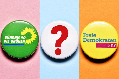 Partei-Anstecker von der FDP und den Grünen mit Fragezeichen