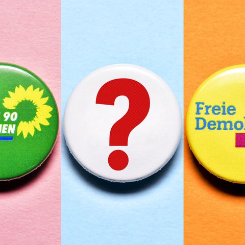 Partei-Anstecker von der FDP und den Grünen mit Fragezeichen