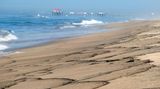 Flecken eines Ölteppichs spülen an den Strand südlich des Piers in Huntington Beach, Kalifornien