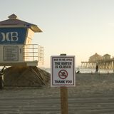 Rettungsschwimmer haben ein Schild aufgestellt, das vor dem Betreten des Wassers warnt