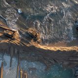 Schaufelbagger versuchen die Ausbreitung des Öls durch Sandbarrieren zu verhindern