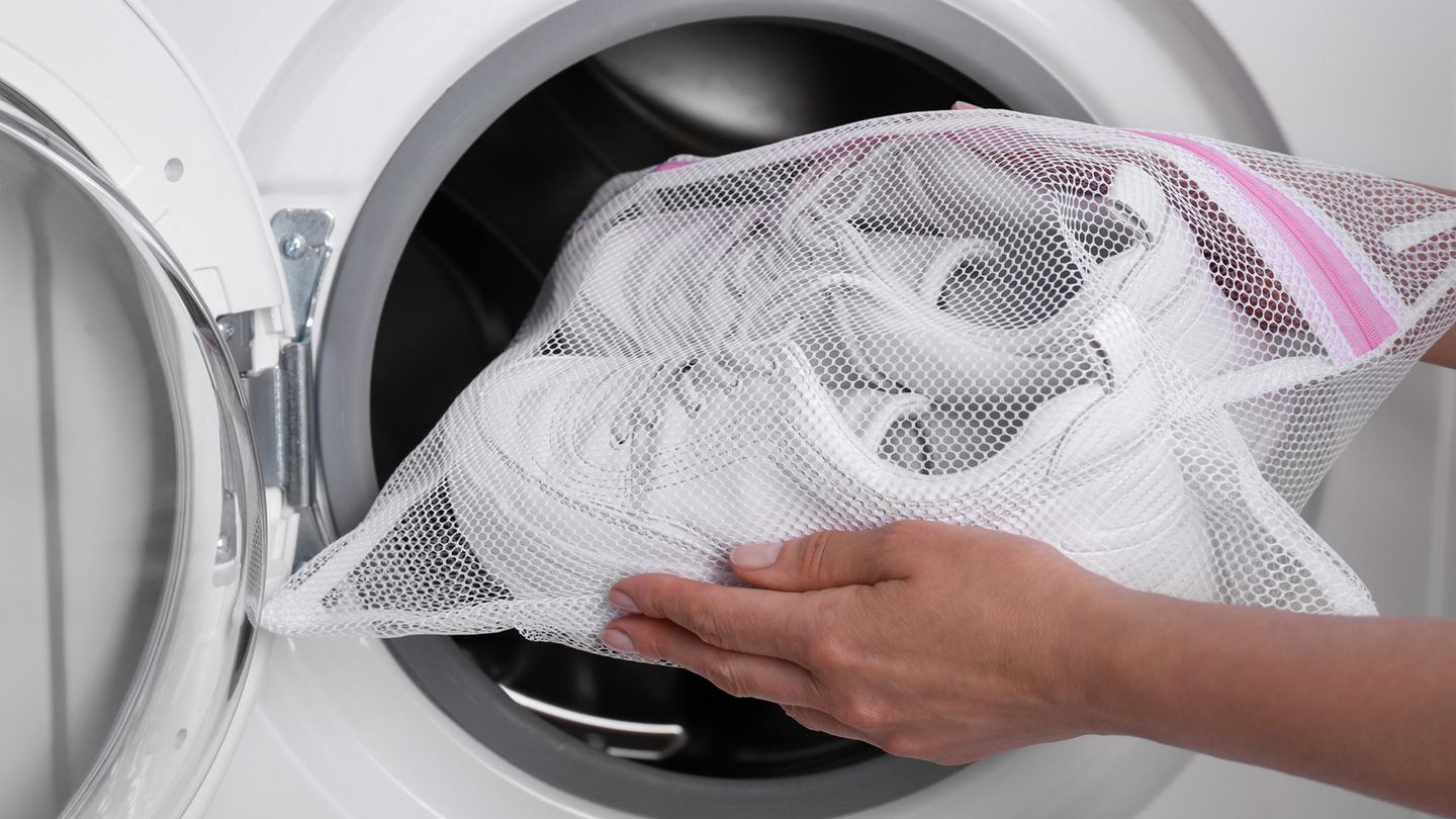 Paar schmutzige weiße Turnschuhe in der Waschmaschine