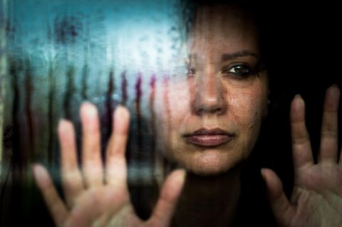 Frau schaut aus dem Fenster