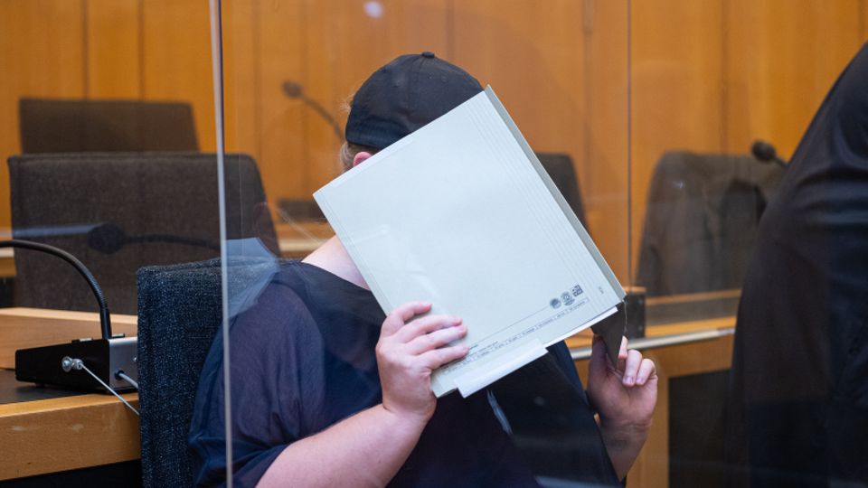Mutter eines Opfers sitzt im Landgericht Münster und verdeckt ihr Gesicht mit einer Mappe