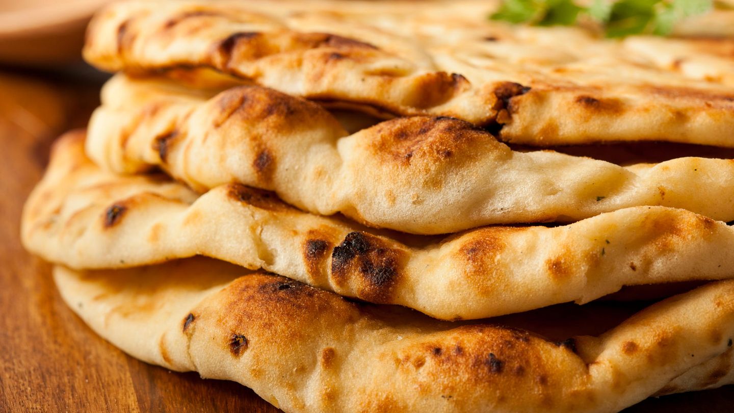 Naan-Brot liegt übereinander gestapelt auf einem Holztisch
