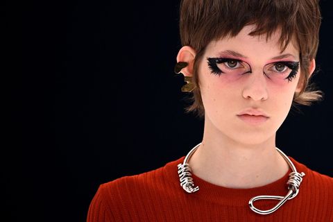 Das Model trägt eine silberne Kette in Galgenform von Givenchy