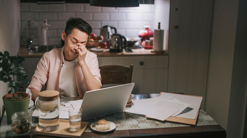 Umfrage mentale Gesundheit Arbeitsplatz: Ein Mann arbeitet im Home-Office und hat Stress
