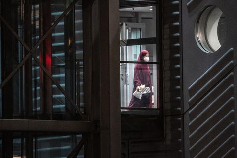 Eine verschleierte Frau mit einer Maske verlässt den Gangway einer Chartermaschine.