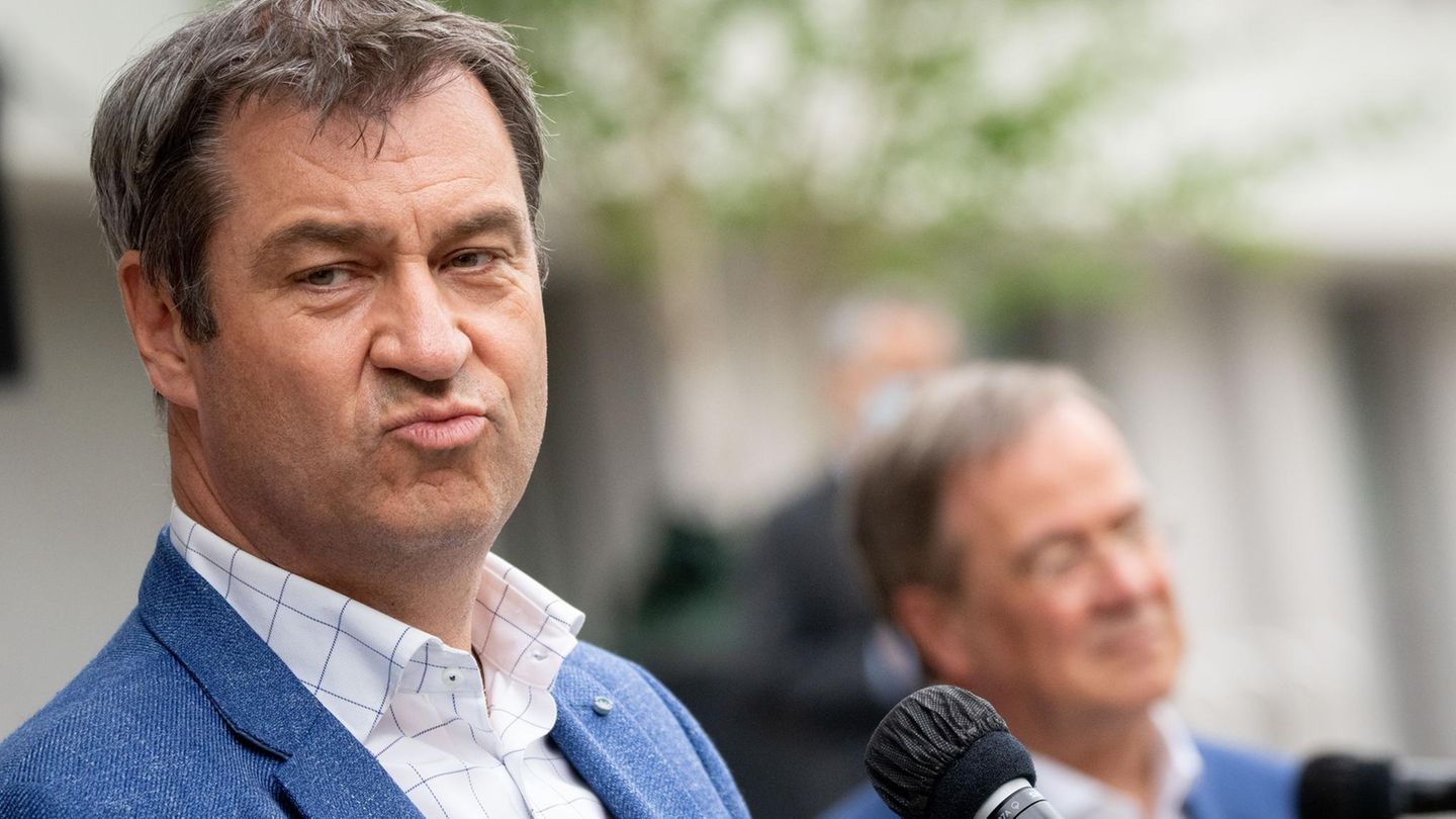Markus Söder im Vordergrund mit einem leidenden Laschet im Hintergrund