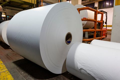 Papier liegt auf großen Rollen in einer Papierproduktionsfabrik