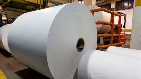 Papier liegt auf großen Rollen in einer Papierproduktionsfabrik