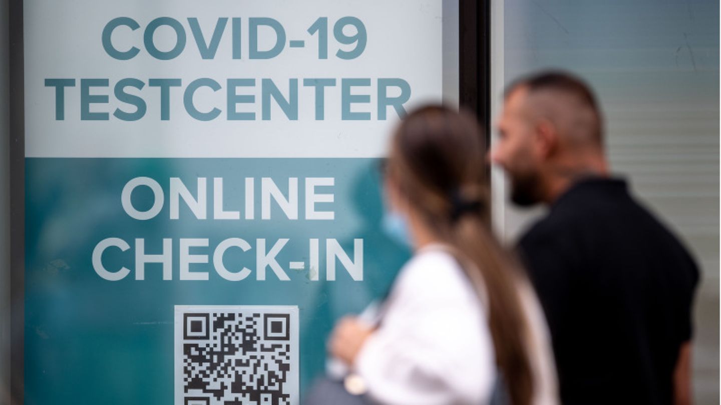 Frau und Mann passieren ein Testzentrum