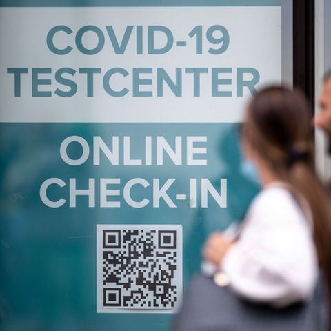 Frau und Mann passieren ein Testzentrum