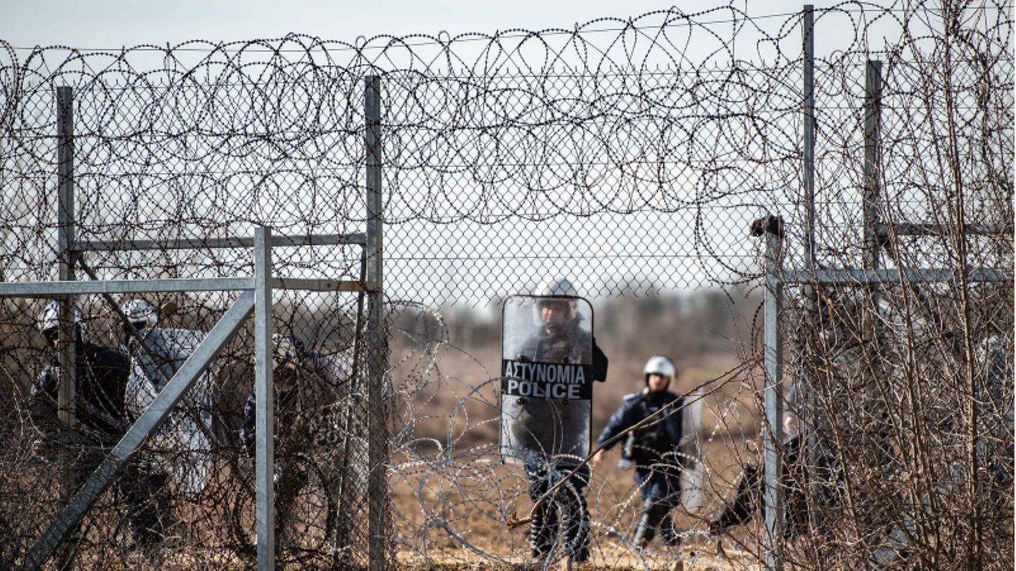 Ein griechischer Polizist steht an einem Loch im Zaun an der griechisch-türkischen Grenze