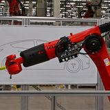 Ein Roboter zeichnet einen Tesla Model Y zum Tag der offenen Tür in einer Produktionshalle der Tesla Gigafactory. Die Werkhallen sind voll mit Hightech, ein Teil der Produktion wird von Maschinen übernomme