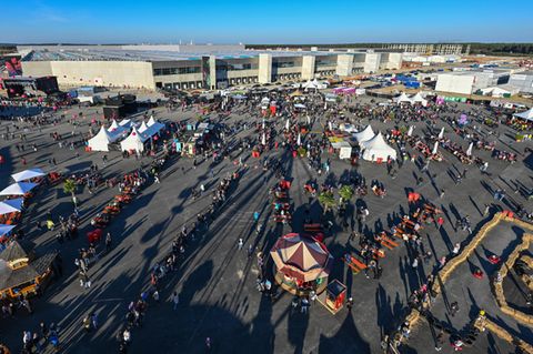 Auf dem Außengelände erinnert das Gigafest mehr an ein Volksfest. Für Kinder gibt es Fahrten mit Tesla-Bobbycars, für die großen Autofans ein Riesenrad und Autoscooter.