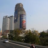 Auch aus einer anderen Perspektive sieht man den einzelnen Zweck der Ruine: Riesige Werbeplakate dominieren den Anblick des Sathorn Unique Tower.