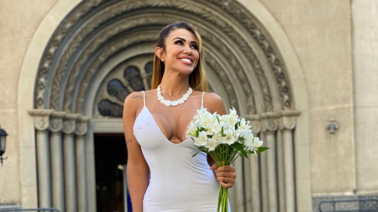 Die brasilianische Influencerin Chris Galêra trägt ein weißes Brautkleid und steht alleine vor einer Kirche