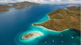 Traumziel Karibik: Segelyachten liegen in einer Bucht vor Sailors Fantasy Island