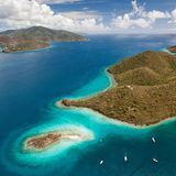 Traumziel Karibik: Segelyachten liegen in einer Bucht vor Sailors Fantasy Island