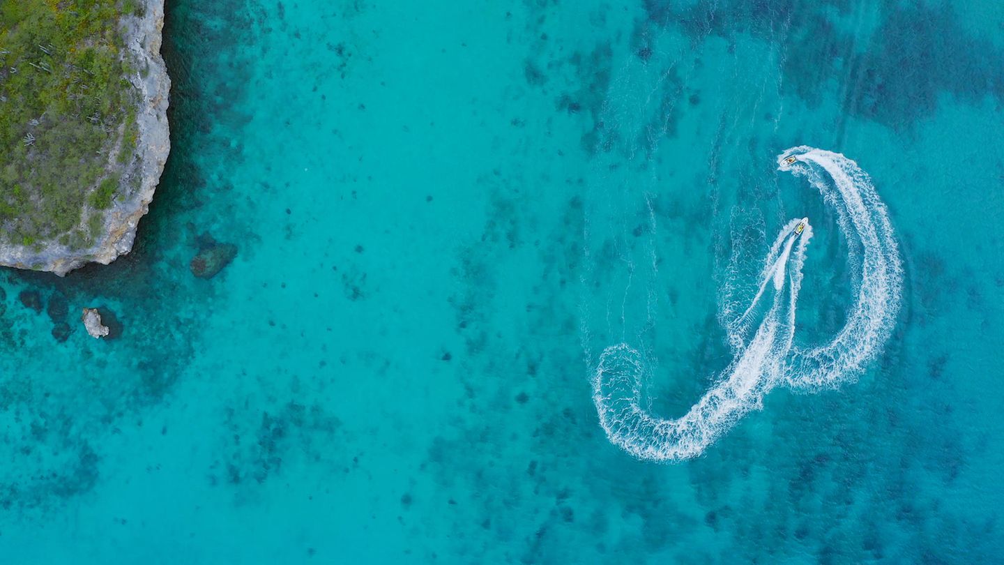Traumziel Karibik: Zwei Jetski-Piloten jagen vor Curaçao durchs azurblaue Meer Traumziel Karibik: Zwei Jetski-Piloten jagen vor Curaçao durchs azurblaue Meer