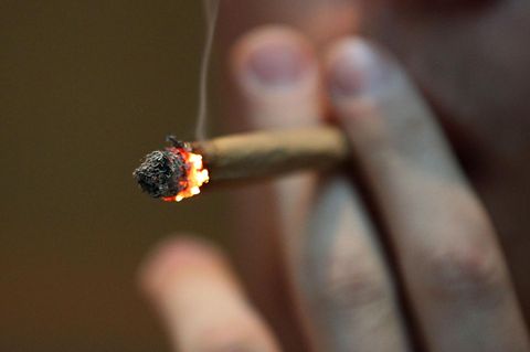 Ein Mann raucht einen Joint.