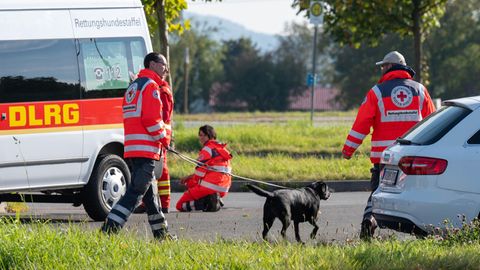 Bayern, Furth im Wald: Einsatzkräfte mit einem Suchhund stehen auf einem Parkplatz an der deutsch-tschechischen Grenze