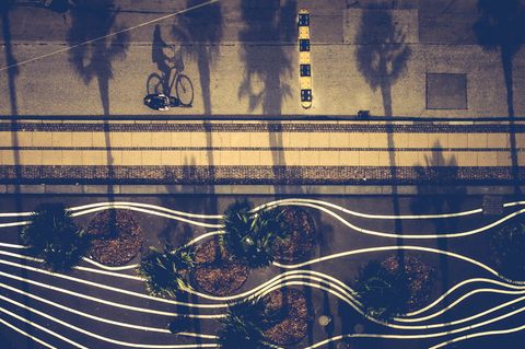 Drohnenfoto eines Fahrradfahrers der durch den Superkilen Park, ein mit weißen Linien gestalteter Platz, fährt.
