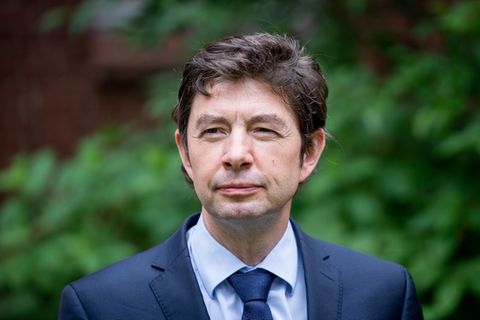 Christian Drosten steht im Grünen und blickt in die Ferne