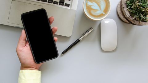 Das iPhone X liegt in einer männlichen Hand.