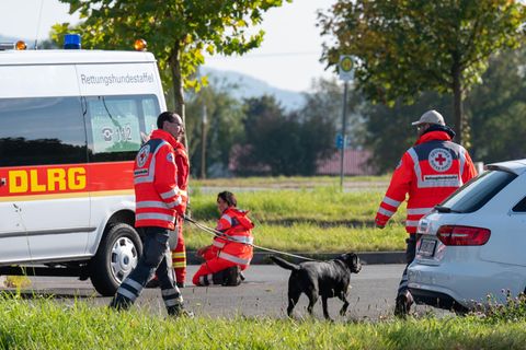Bayern, Furth im Wald: Einsatzkräfte mit einem Suchhund stehen auf einem Parkplatz an der deutsch-tschechischen Grenze