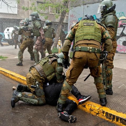 Sicherheitskräfte halten einen Demonstranten bei den Protesten in Chile fest