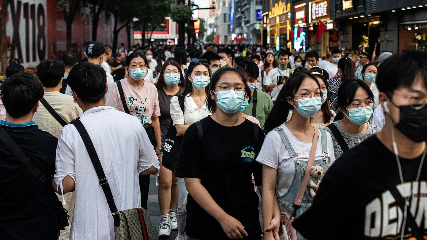 Passanten in der chinesischen Stadt Wuhan in der Provinz Hubei tragen Mund-Nasen-Schutz