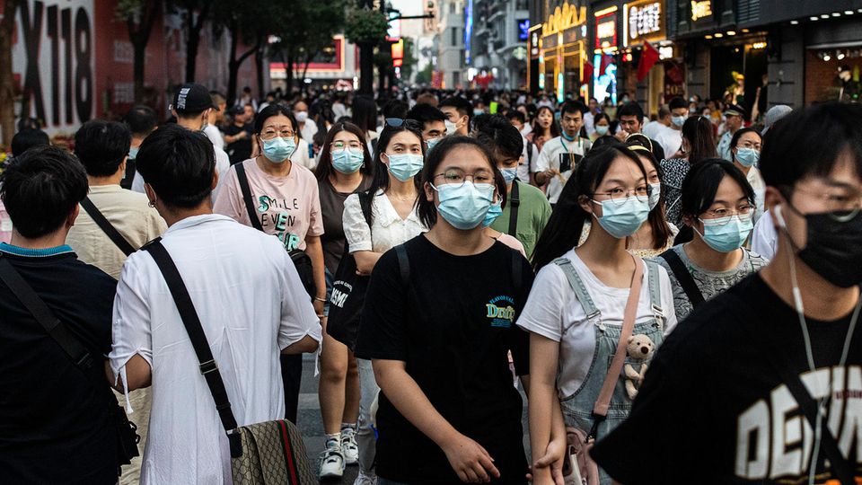 Passanten in der chinesischen Stadt Wuhan in der Provinz Hubei tragen Mund-Nasen-Schutz
