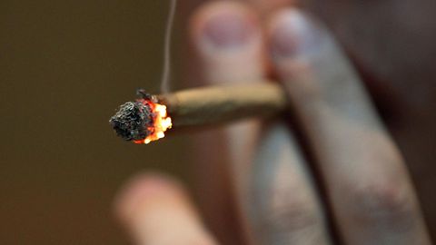 Ein Mann raucht einen Joint.