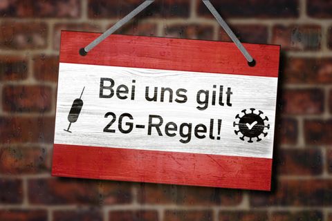 Schild mit Aufschrift "Bei uns gilt 2G-Regel!" hängt an einer Wand