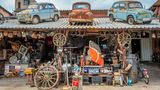Kočerinovo, Bulgarien, 2016: Kuriositätenkabinett an der Straße zum Rila-Kloster. Der Inhaber sammelt Antiquitäten und Trödel. Der Großteil stammt aus der Zeit des Sozialismus, so wie die Stalin-Büste im orangefarbenen Auto. Neugierige Besucher dürfen gegen Spende stöbern.