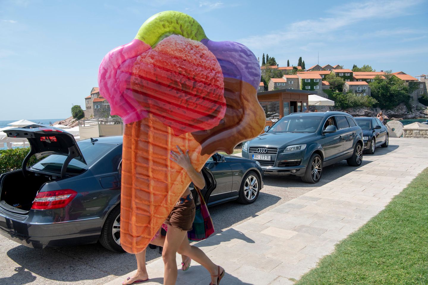 Ausstellung "Facing the Balkans": Sveti Stefan, Montenegro, 2018: Junge Frauen auf dem Weg zum Strand. Sveti Stefan ist eines der teuersten Reiseziele Montenegros. Besonders exklusiv ist die vorgelagerte Insel, die seit den 1950er Jahren Prominenz anzieht. Marilyn Monroe und Willy Brandt waren ebenso zu Gast wie die Beckhams und George Clooney. Sveti Stefan, Montenegro, 2018: Junge Frauen auf dem Weg zum Strand. Sveti Stefan ist eines der teuersten Reiseziele Montenegros. Besonders exklusiv ist die vorgelagerte Insel, die seit den 1950er Jahren Prominenz anzieht. Marilyn Monroe und Willy Brandt waren ebenso zu Gast wie die Beckhams und George Clooney.
