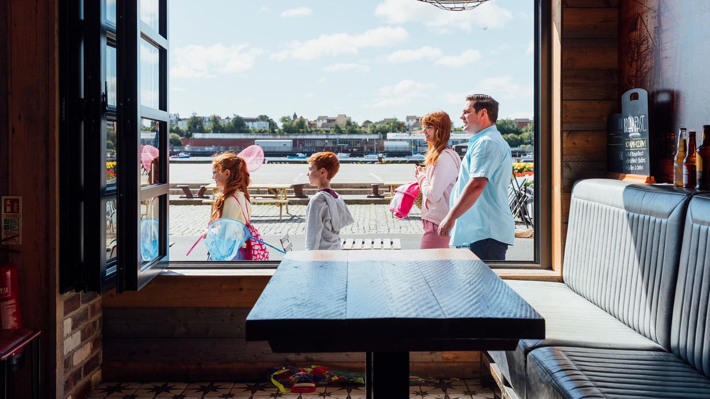 Familie mit zwei Kindern steht vor einem Restaurant