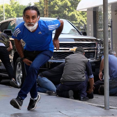 Libanon, Beirut: Personen gehen hinter einem Auto in Deckung