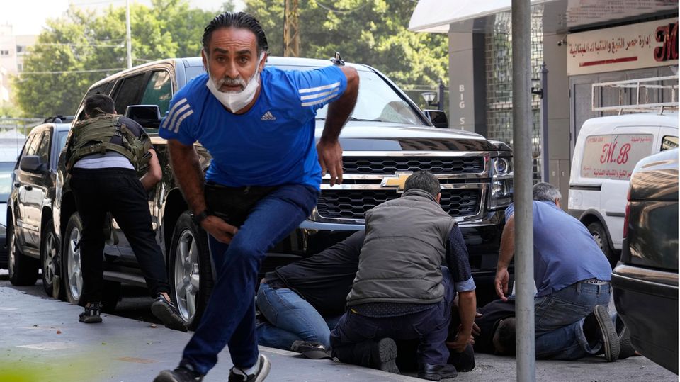 Libanon, Beirut: Personen gehen hinter einem Auto in Deckung