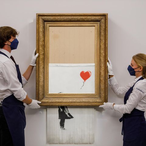 Mitarbeiter von Sotheby's zeigen das geschredderte Werk Girl with Balloon von Banksy